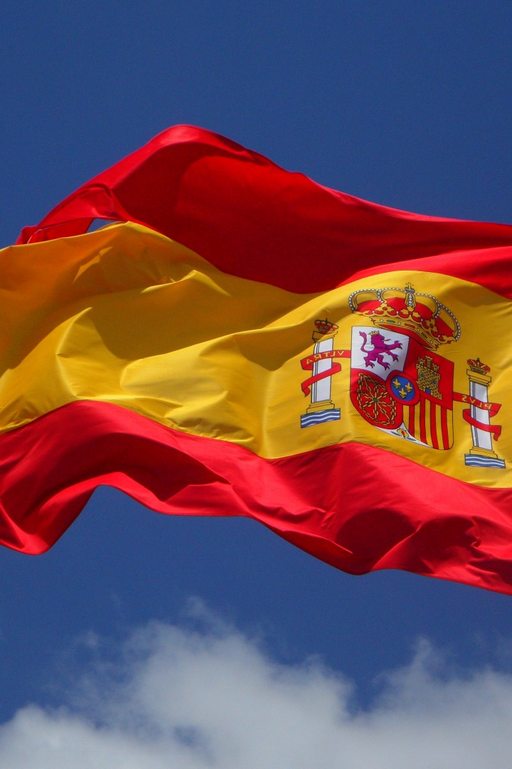 Развевающийся испанский флаг на фоне неба 720x1080