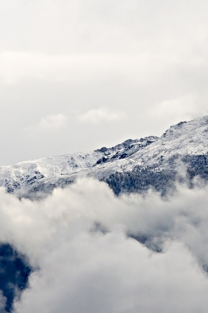 Заснеженные горы над облаками 720x1080
