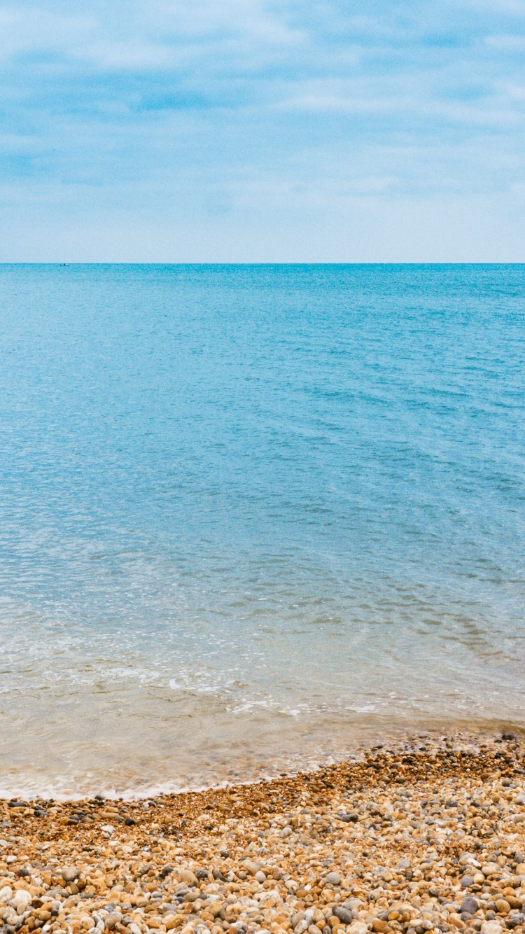 Каменистый пляж и синее море 750x1334